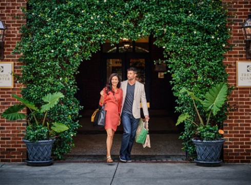couple walking under entrance of