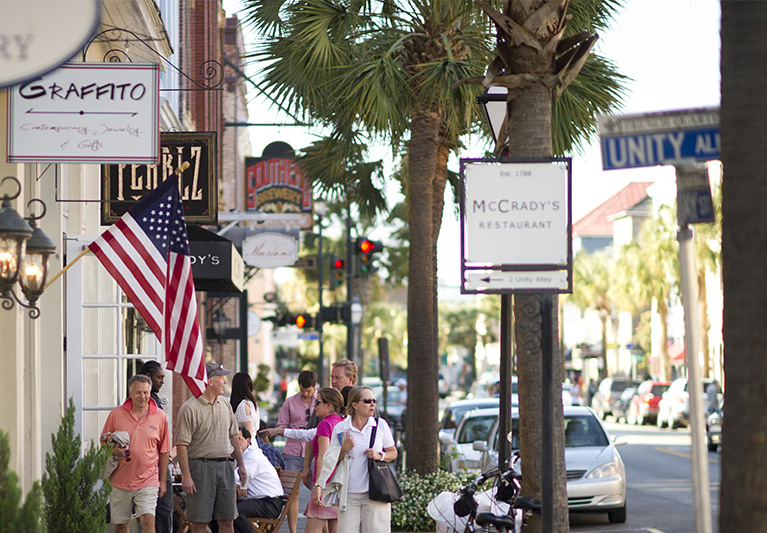 Group of people walking down street with shops