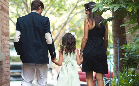 Couple with daughter walking down brick path