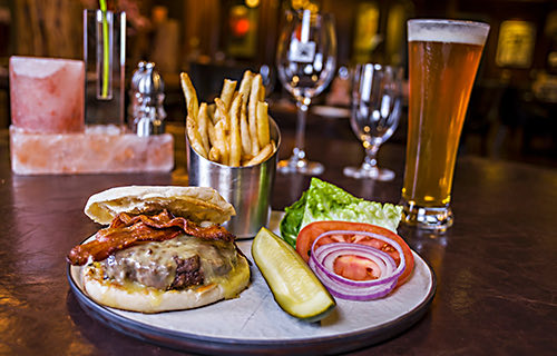 plate with a hamburger, fries and salad. A beer on the side