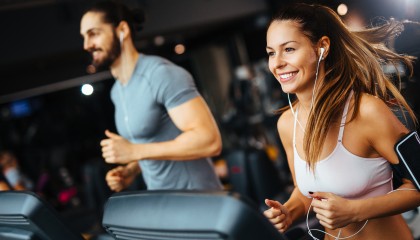 gentlemen and a lady doing some exercise at the gym while they are listening music 