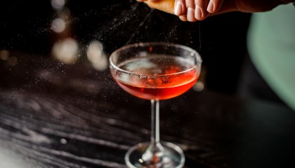bartender hands finishing the  fancy red cocktail
