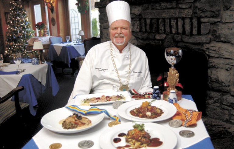Chef sitting next to table of prepared food