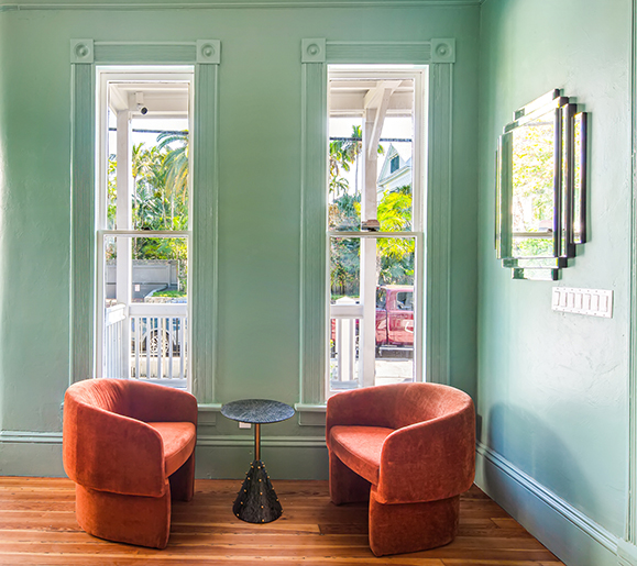 green walls with two orange velvet chairs