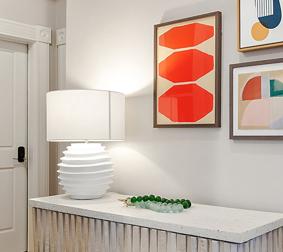 view of a corner of a suite with a lamp and artwork on the walls