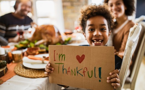 kid with Im thankful sign