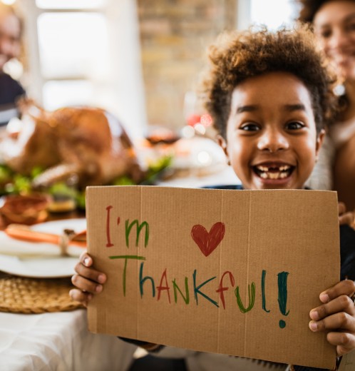 kid with Im thankful sign