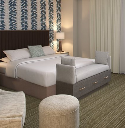 King bedroom with a patterned accent wall and seating