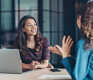 a woman speaking to another woman in a meeting
