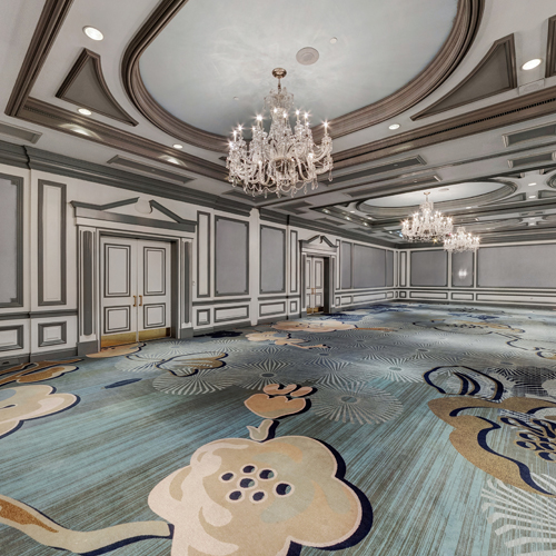 large ballroom with teal patterned carpet and elegant chandeliers