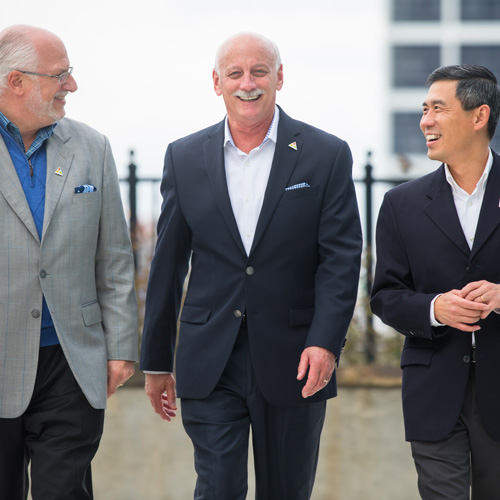 three businessmen walking and laughing