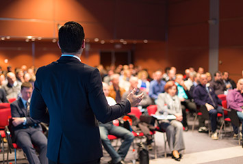 a business man talking to a room full of people