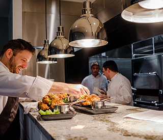 a chef garnishing a dish before it is served