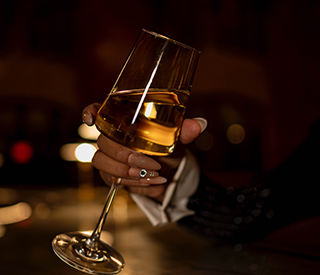 close up of a woman's hand holding a glass of wine