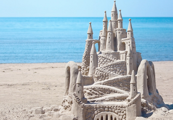 Elaborate sand castle with ocean in the back