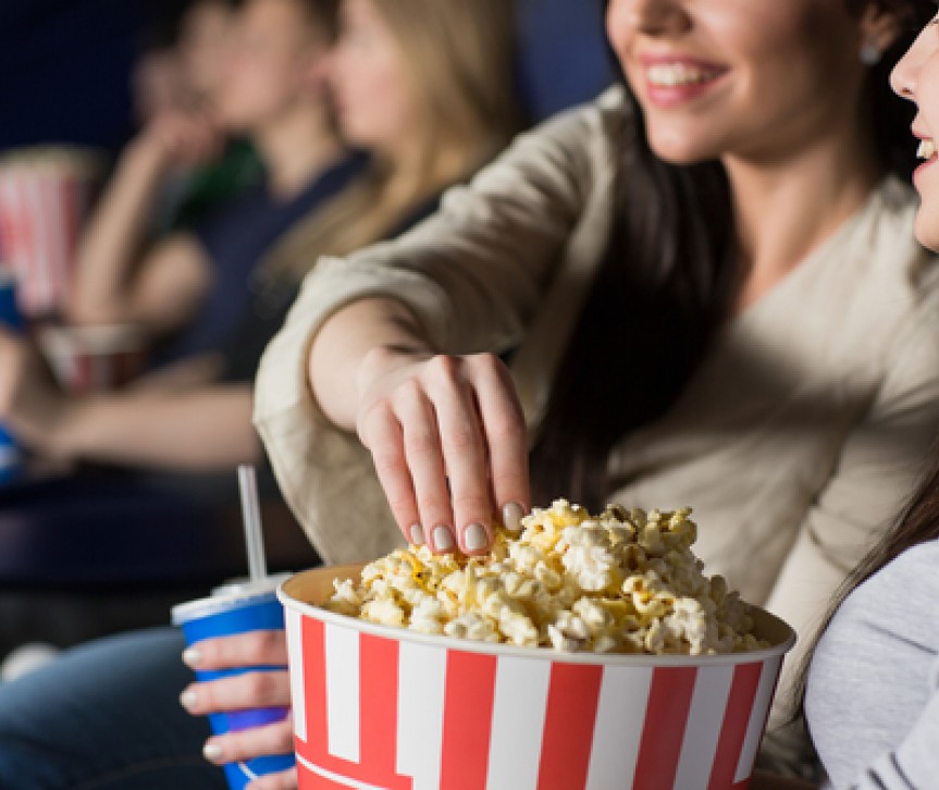 girls eating popcorn in movie theater