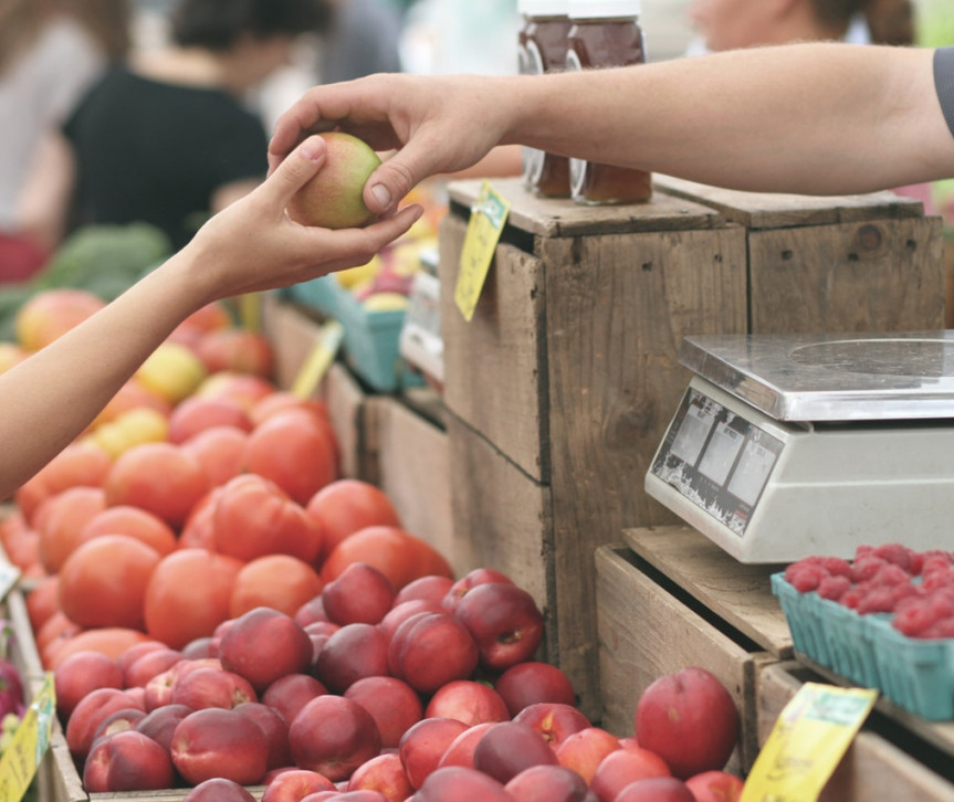 a person buys fruit at farmers market