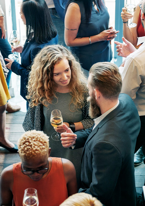 lots of people having a conversation with wine glasses in some hands