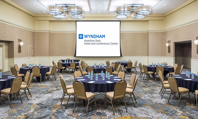 Room with circular tables & large projection screen