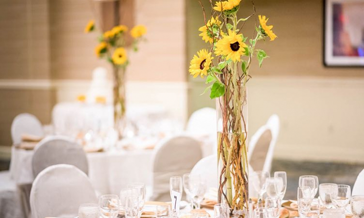 Small sunflower arrangement on tables for reception