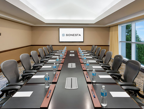 Long wooden meeting table with chairs & TV