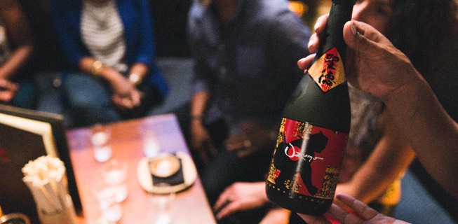 hand holding a bottle of sake