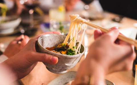 person-holding-a-bowl-eating-noodles-with-chopsticks-5b4fb391bc5f7.jpg