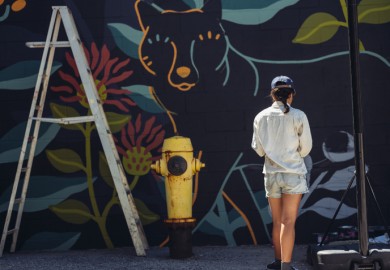 woman in front of mural