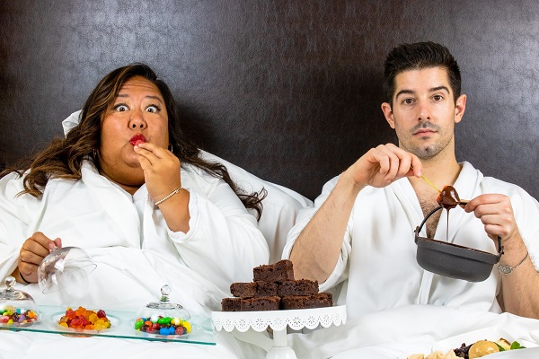 couple in bed eating candy