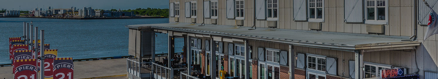 Side angle view of a building next to the water with a covered outdoor seating area