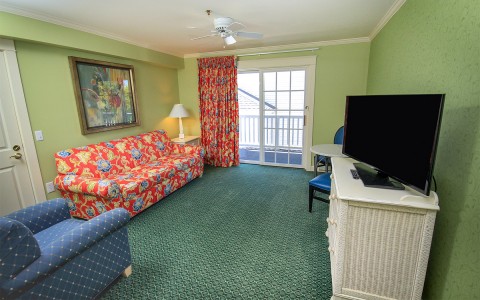hotel room with couch, sofa chair and tv