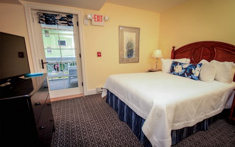 room with a queen size bed, dresser, and tv