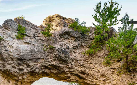 View of a natural arch next to a water source