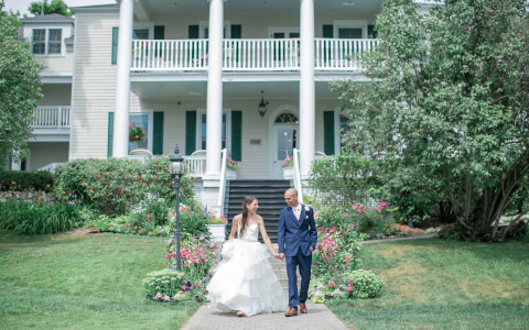 A wedding couple walking in front of the property