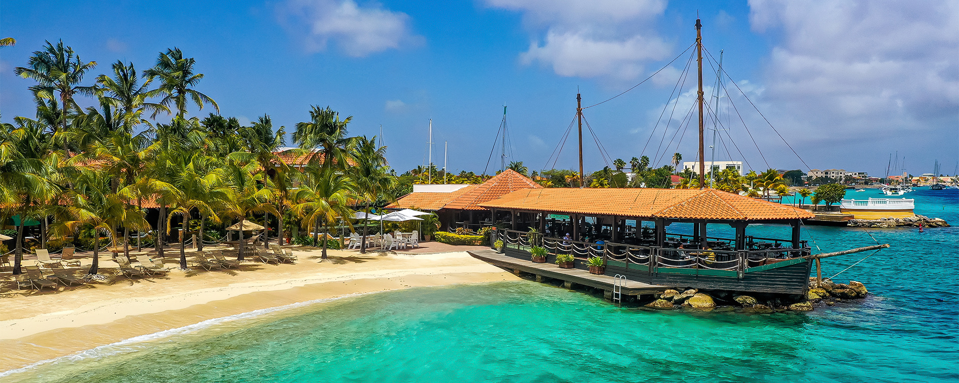beach with crystal clear water with a boat docked