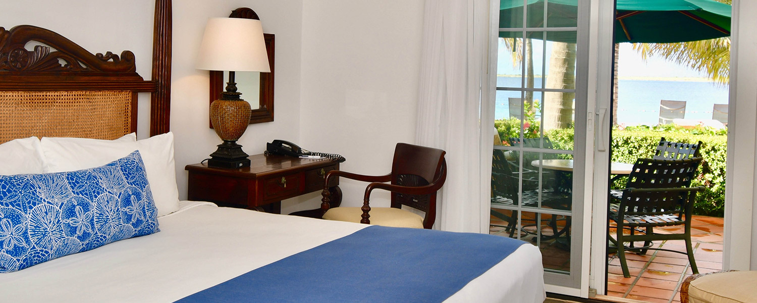 king bed with blue bedding and dark wooden work desk on the side