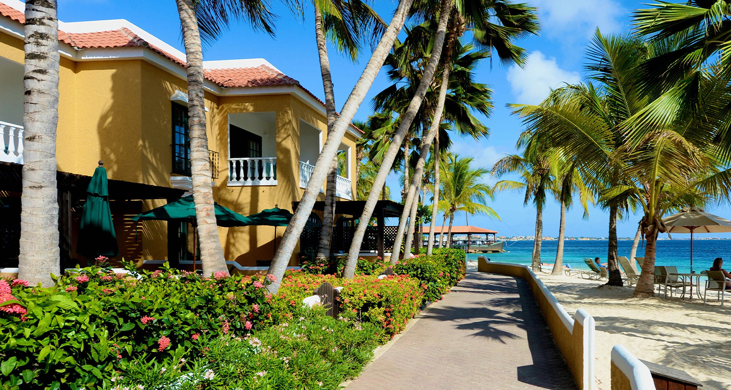 walkway with buildings/villas on the left and the ocean on the right