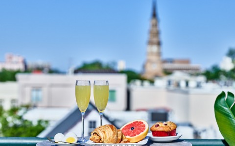 view of breakfast platter and two mimosas on rooftop terrace