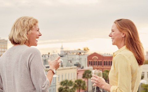 two women enjoying a glass of wine on the rooftop