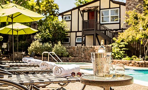 Small table with wine next to loungers by the pool