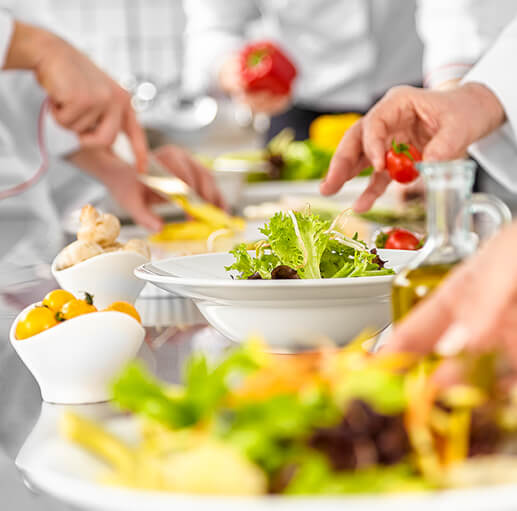 Assembly line of cooks in the kitchen prepping meals
