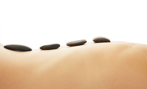 Close up of rocks on someones back while getting massage