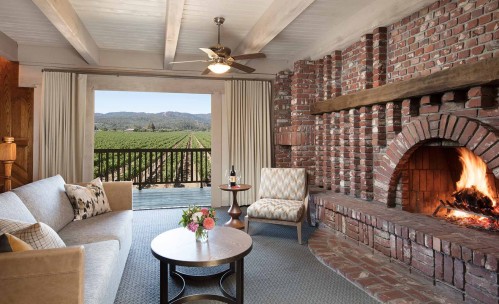 suite living room with fireplace, couch and vineyard view