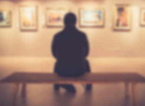 man on bench in art gallery