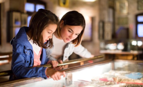 mother and daughter looking into glass case at museum