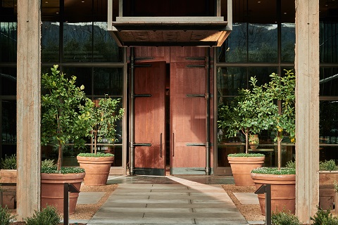 entryway leading to a brown wood door with stone path