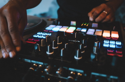 close up view of a man playing music on a dj controller