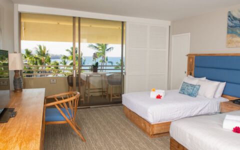 hotel room with palm trees and partial ocean view