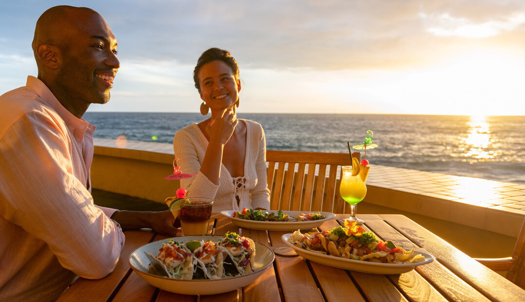 couple seated with food enjoying sunset on Kailua-Kona bay