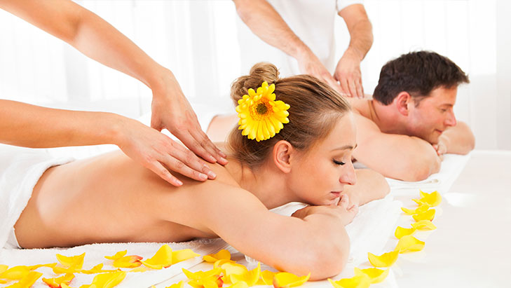 view of a woman receiving a massage with a yellow flower in her hair